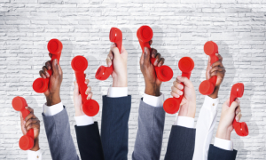 Business people holding red phone.